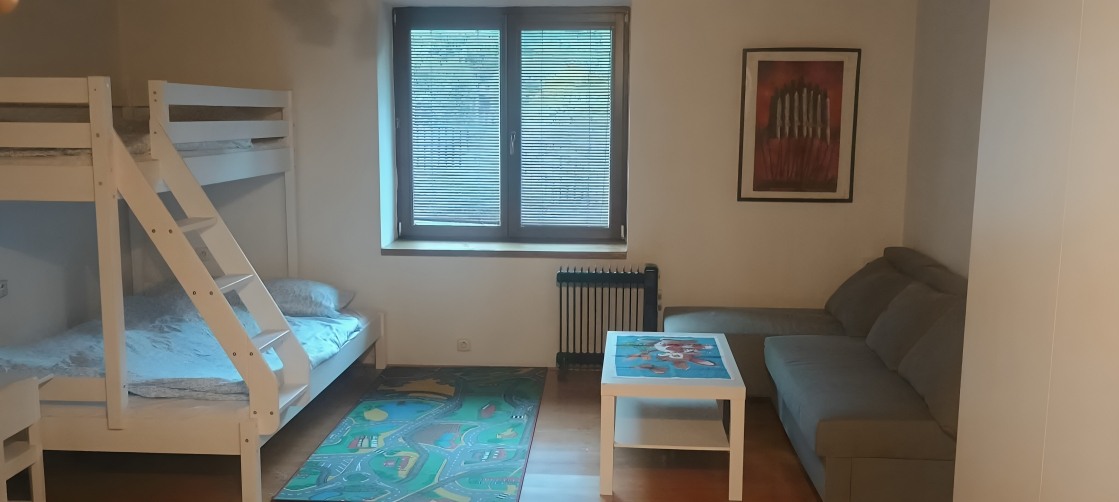 Obytná místnost s patrovou postelí a gaučem
