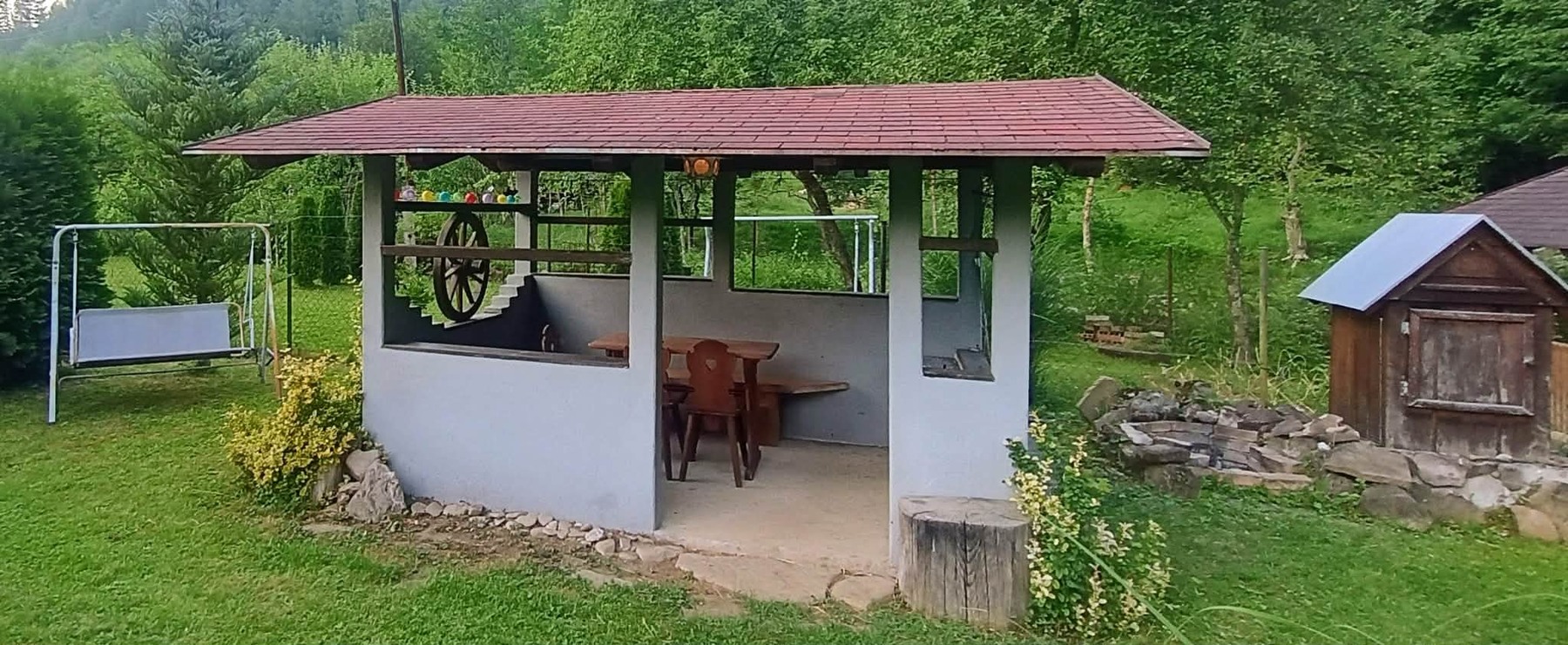 Zahrada se zastřešeným posezením a ohništěm